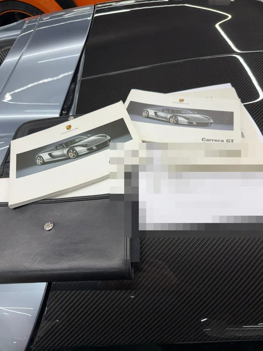 Carrera GT – Handbuchsatz und Dokumentenmappe auf Sichtcarbon